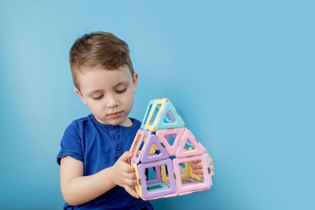 Мальчик просматривает фигуру в цветном конструкторе с соединением магнитов