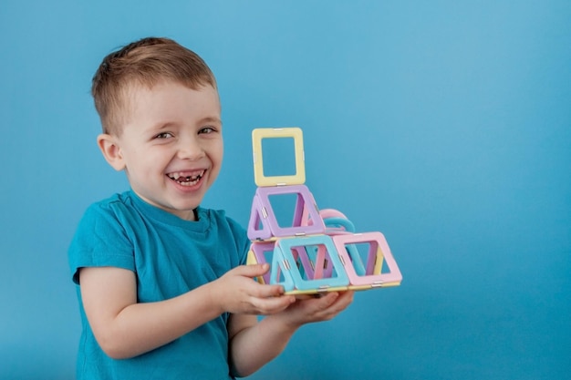 Фото Мальчик смотрит через форму в цветовом конструкторе с соединением магнитов