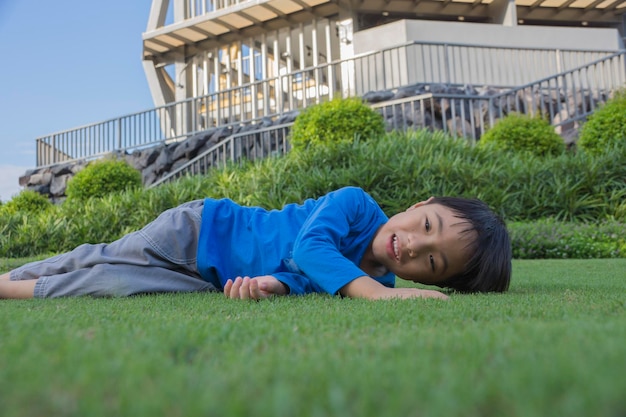 裏庭の草の上に横たわっている少年