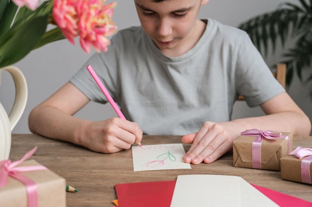 The boy makes a card for mother's day Children's drawings