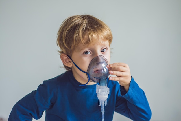 Boy making inhalation with a nebulizer at home.