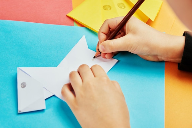 Foto ragazzo che fa origami di cane di carta