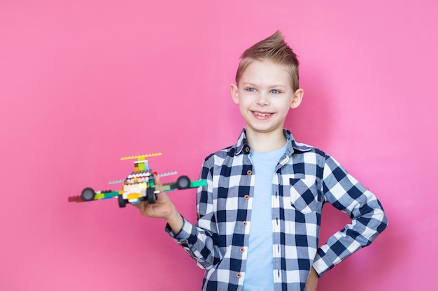 Фото Мальчик на розовой стене играет в робота