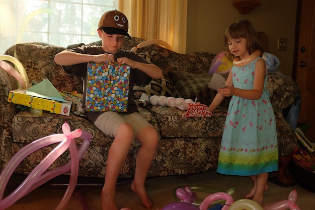 Фото Мальчик открывает подарок с сестрой дома