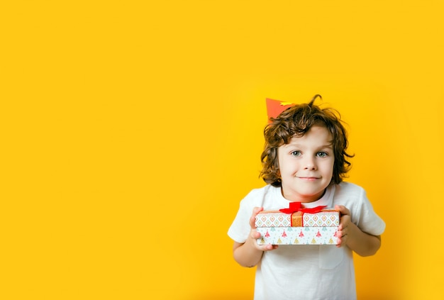 Boy in party cap holding gift