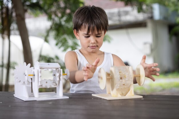 A boy and pay attention to learning the simulation mechanism
robot model wooden on table at home