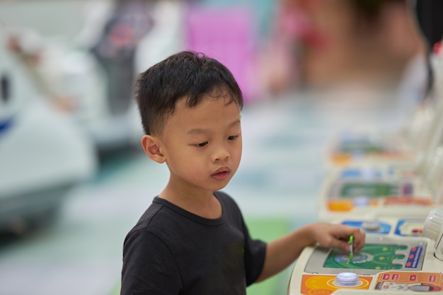 Boy play game in arcade alone