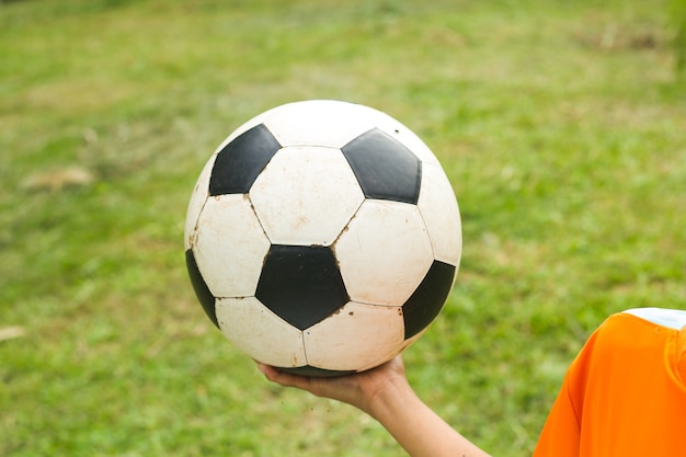 Il ragazzo gioca a calcio nel campo di erba.