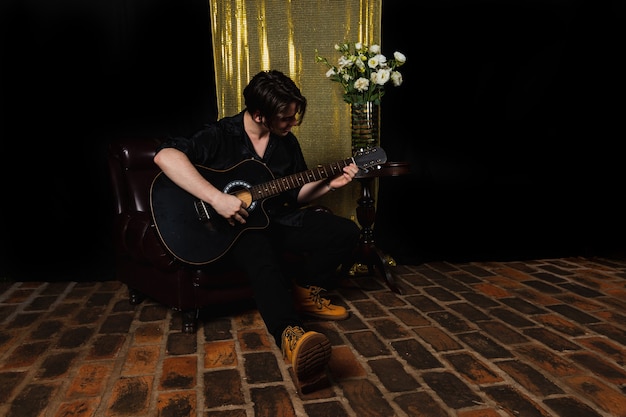 Foto ragazzo che suona la chitarra acustica a casa