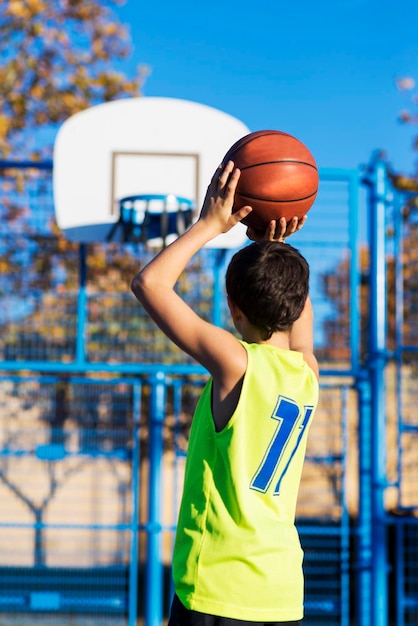 Boy playing basketball in court