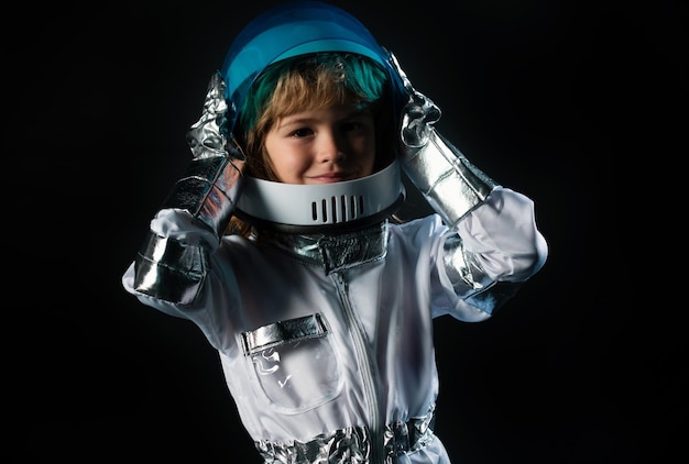 Foto ragazzo che gioca per essere un astronauta con casco spaziale e tuta di metallo bambino ragazzo che gioca con casco spaziale