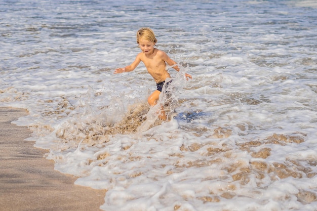 Boy playing on the beach in the water