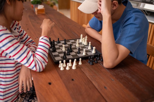 a boy playing chess with a black and white chess board