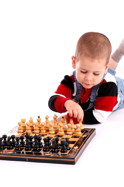 A boy playing chess with a chess board.