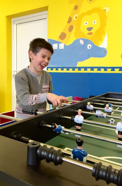 Foto ragazzo che gioca a calcio da tavolo