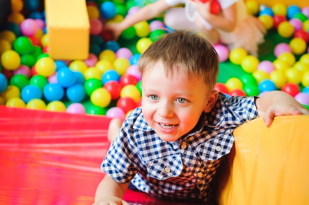 Boy playing on the playground, in the children's maze with balls