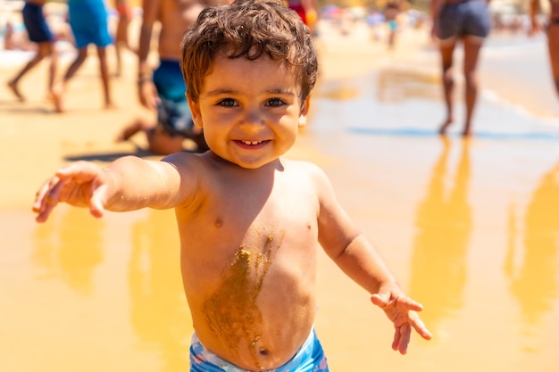 Boy playing in the sand and having fun Praia do Barranco das Belharucas beach Albufeira Algarve Portugal