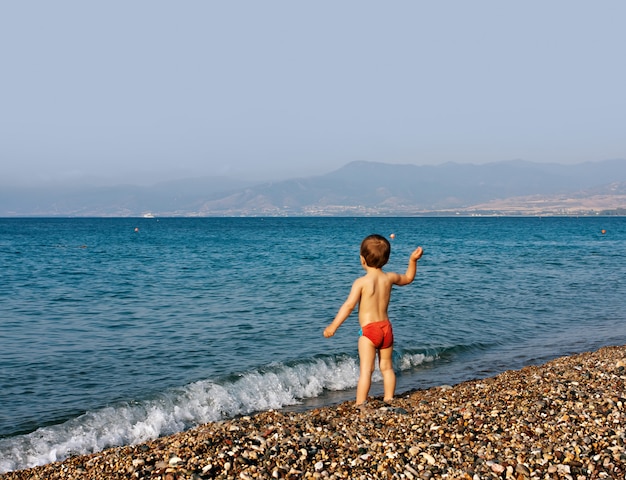 海のビーチで遊んでいる少年