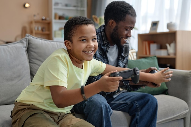 Boy playing video game with father