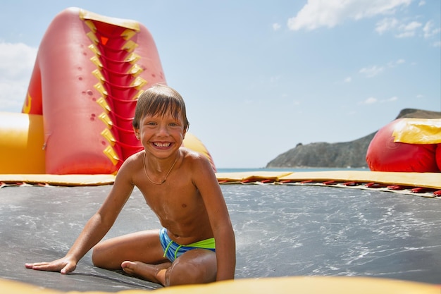 Boy playing on water trampoline Vacation and holiday concept