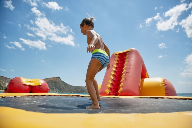 Boy playing on water trampoline Vacation and holiday concept
