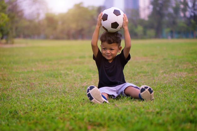 Photo boy playing with ball at park