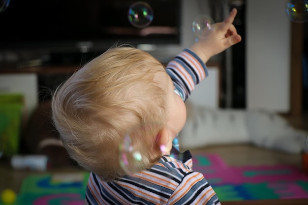 Foto ragazzo che gioca con le bolle a casa