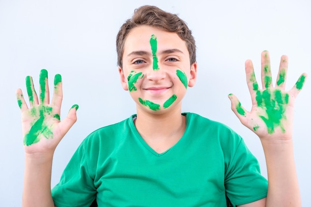 Boy playing with colors using his hands and his face