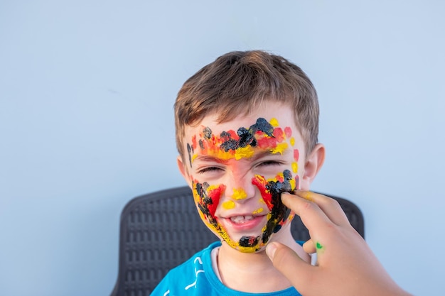 Boy playing with colors using his hands and his face