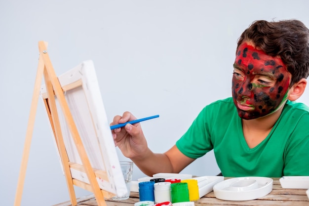 Boy playing with colors using his hands and his face