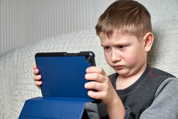 自宅でデジタルタブレットで遊ぶ少年。検疫。家にいる。