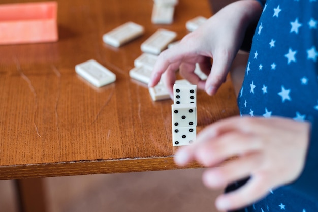 Boy playing with dominoes close up Build a domino fence close up