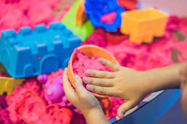 Boy playing with kinetic sand in preschool. the development of fine motor concept. creativity game concept