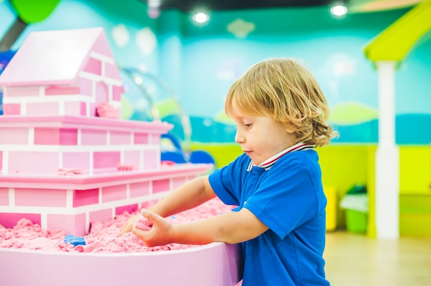 Boy playing with kinetic sand in preschool