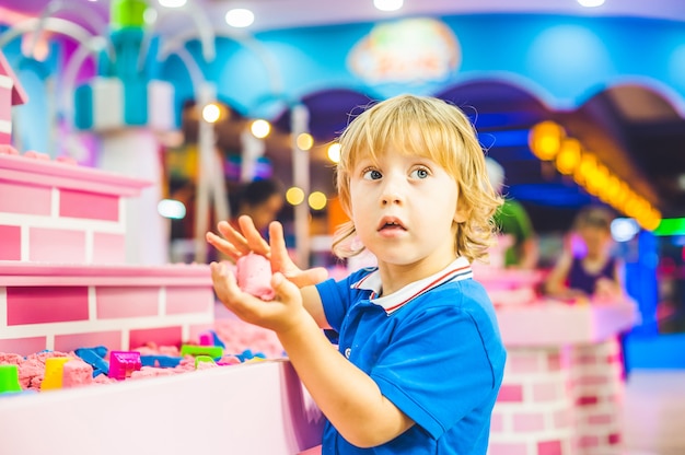 Boy playing with kinetic sand in preschool