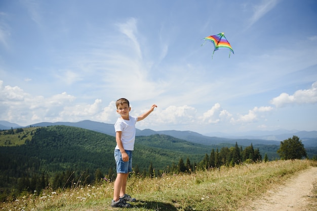 Boy playing with a kite in the mountains