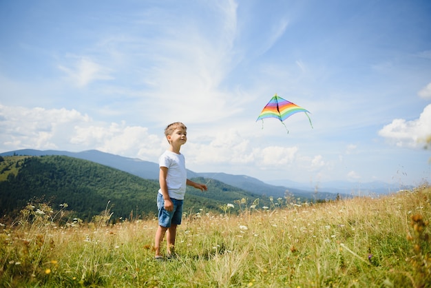 Boy playing with a kite in the mountains