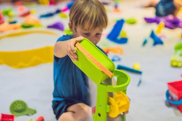 Boy playing with sand in preschool. The development of fine motor concept. Creativity Game concept.