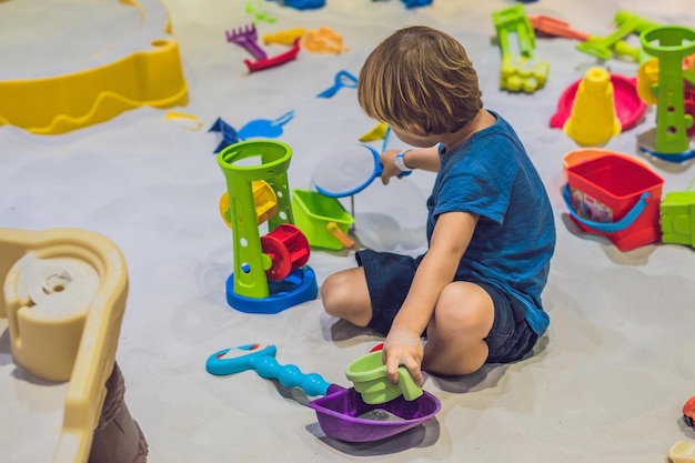 Boy playing with sand in preschool. The development of fine motor concept. Creativity Game concept.