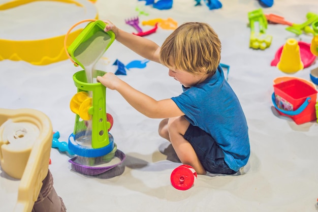 Boy playing with sand in preschool. The development of fine motor concept. Creativity Game concept.