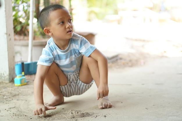 家のエリアで土で遊ぶ男の子