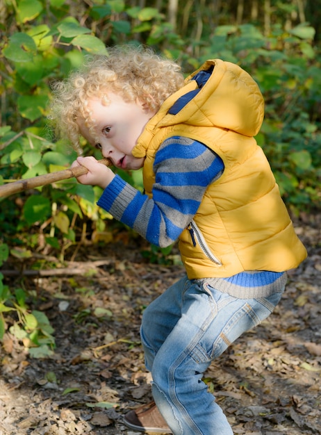 Boy playing with stick like with gun 