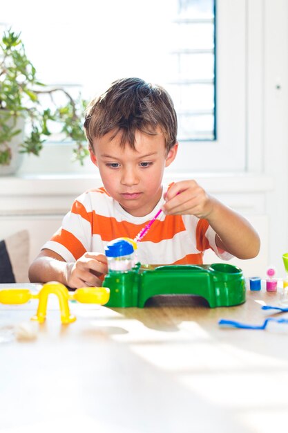 Boy playing with toys at table against window