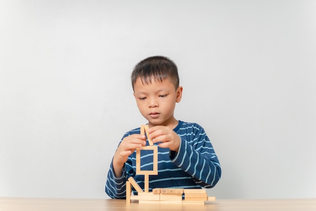 Boy playing with wooden blocks at home