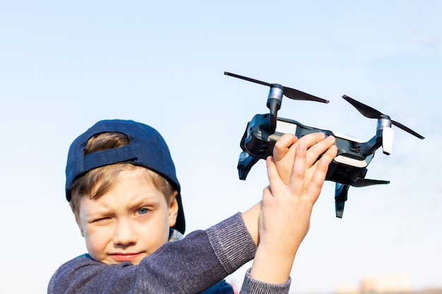 Boy plays with his drone in the park