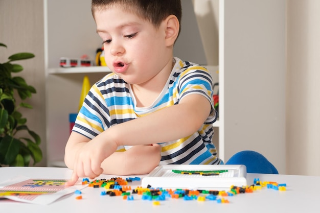 A boy plays with a mosaic.