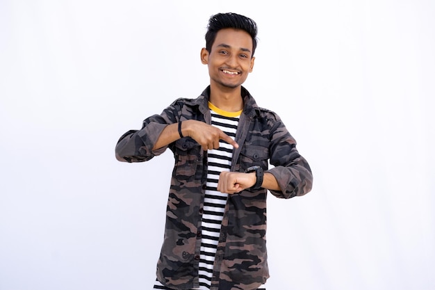 Boy pointing to Wristwatch and Smiling in the Camera isolated in a white background