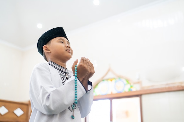 Boy praying to God with arm open