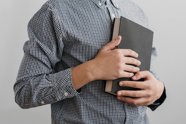 Photo boy praying while holding a holy book