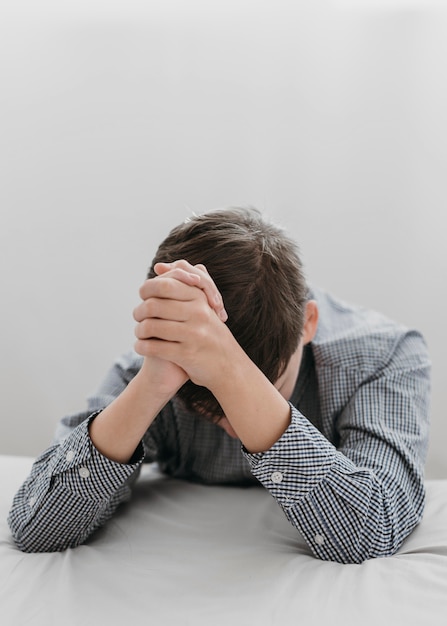 Boy praying with his head down